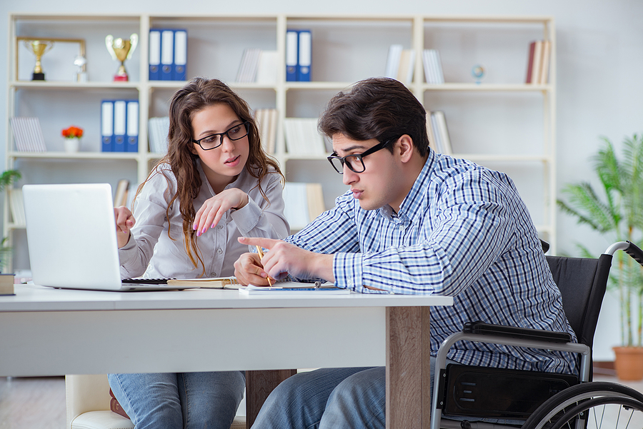 Main in wheelchair studying with laptop